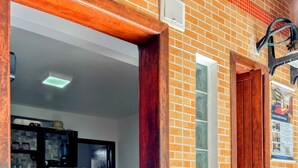 Eine Küche mit Kühlschrank, Holzstühlen und einer Ziegelwand.