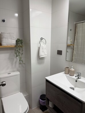 Une salle de bain moderne avec des toilettes, un lavabo et un miroir.