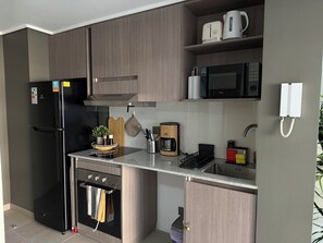 Une cuisine moderne équipée d’un réfrigérateur, d’un four à micro-ondes, d’une cuisinière et d’une machine à café.