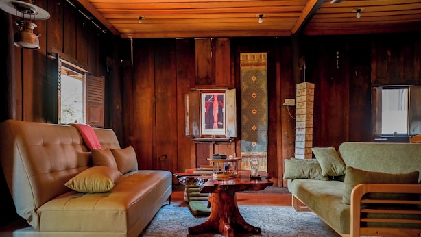 A wooden interior with two sofas, a coffee table, and a patterned rug. - HoP:House of Peace in Heritage Area; walk to evthg (Luang Prabang)