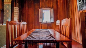 A wooden room with a long table and chairs, a window, and a framed picture on the wall. - HoP:House of Peace in Heritage Area; walk to evthg (Luang Prabang)