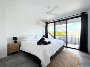 A bedroom with a bed, a nightstand, a ceiling fan, and a view through a sliding door to the outside. - Beautiful 2-bedroom apartment in New Farm perfect for relaxing FREE PARKING (New Farm)