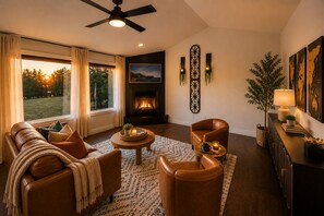 Ein Wohnzimmer mit Kamin, Ledermöbeln und Blick ins Freie.