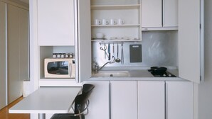 Studio Deluks, pemandangan taman | Dapur pribadi | Lemari es, microwave, kompor, dan peralatan masak/sendok-piring