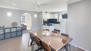 A modern kitchen with white cabinets, a black countertop, and a built-in oven. - Family 3-Bed Retreat Near Batehaven Beach (Batehaven)
