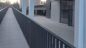 Un edificio moderno con un paseo peatonal cubierto y una entrada de vidrio.