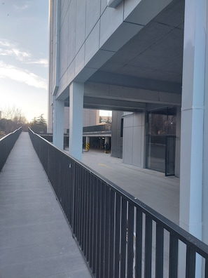 Un edificio moderno con un paseo peatonal cubierto y una entrada de vidrio.