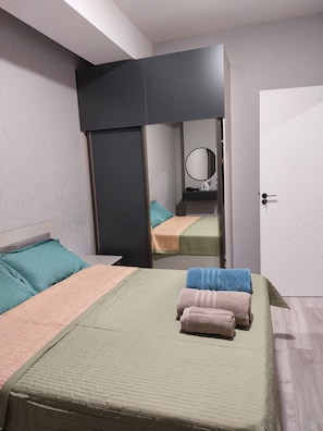 Un dormitorio con dos camas, un espejo y un armario.