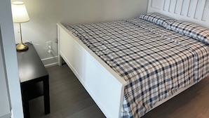 Ein Schlafzimmer mit einem Bett, einem Nachttisch und einer Lampe.