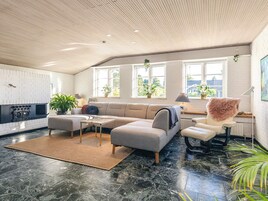 En moderne stue med en hjørnesofa, et sofabord og en pejs.