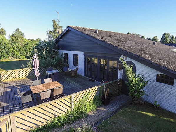 A residential property with a deck, outdoor seating, and a garden area. - 4 Star Holiday Home in Vaeggerlose (Vaeggerlose)