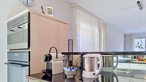 Eine moderne Küche mit Kaffeemaschine, Wasserkocher und Backofen.