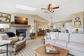 A living room with a fireplace, a sofa, a coffee table, and a ceiling fan. - Kick App VIEWS! Mt Cabin w/Hot Tub +Fireplace (Seven Devils)