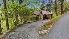 A rustic cabin with a stone exterior, a wooden deck, and a gravel driveway. - Kick App VIEWS! Mt Cabin w/Hot Tub +Fireplace (Seven Devils)