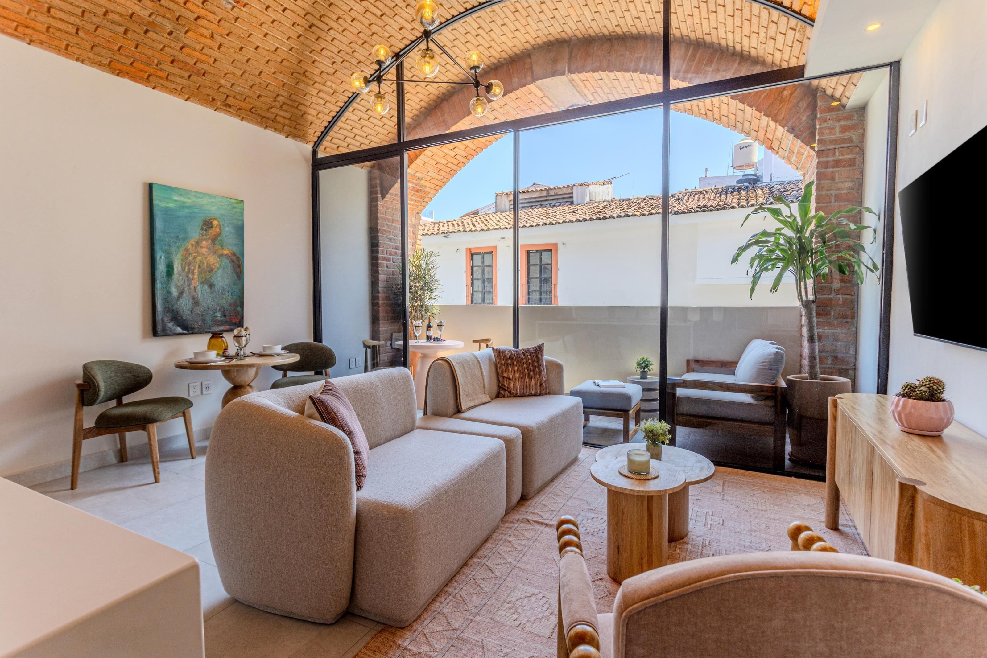 A modern living room with a sectional sofa, a coffee table, and a dining area with a small table and chairs.