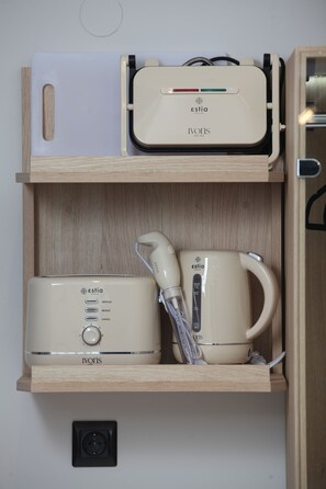A wooden shelf with an espresso machine, a coffee maker, and a small appliance with a control panel. - Casa Da Luz (Thessaloniki)