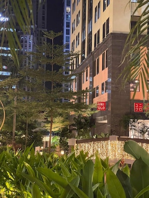A modern building with a sign reading 'UNIOLO' and surrounded by greenery. - Elegant Comfy Unit in Eastwood City (Quezon City)