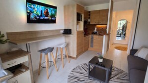 A compact living space with a kitchen, bar area, and seating. - The Golf Studio. Swimming pool, close to beach, walks, golf course, shops and restaurants. (Mandelieu-la-Napoule)