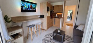 Un espacio habitable compacto con cocina, barra y asientos.