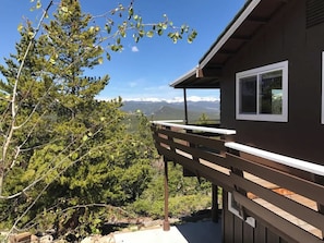 A wooden deck with a view of a mountainous landscape.