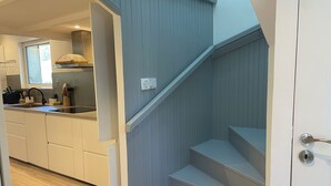 Moderni keittiö, jossa on valkoiset kaapit, sisäänrakennettu uuni ja ikkuna.