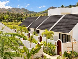 Un edificio moderno con varias habitaciones, fachada blanca y techo inclinado con paneles solares.