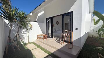 A modern house with a patio, a bed, and a dining area.