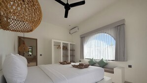A bedroom with a bed, a wardrobe, a ceiling fan, and a window with curtains. - Kairos boutique sports hotel (Selong Belanak)