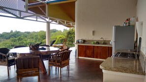 A kitchen with a granite countertop, wooden cabinets, and a stainless steel sink. - Ocean View Ridge Residence/Pool/4BD-5BA+Office/Wifi/Dominical area/ 30-120 days (Matapalo)