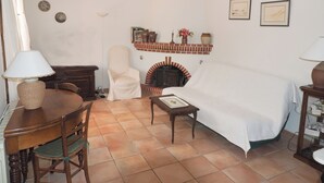 Ein Zimmer mit Kamin, Esstisch, Stuhl, Sofa und Bett.