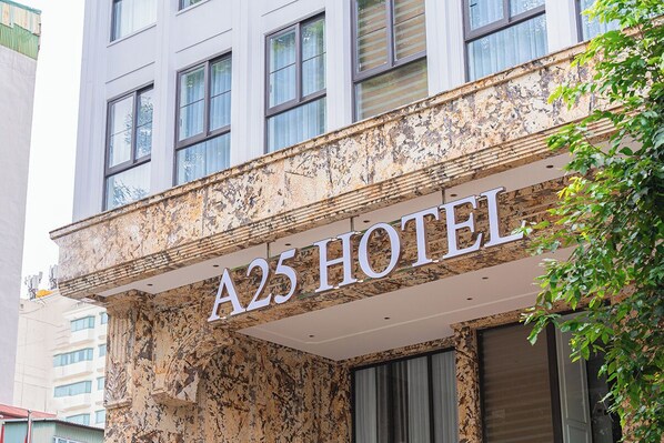 A hotel sign with 'A25 HOTEL' written on a textured facade.
