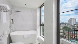Un baño moderno con una bañera independiente, inodoro y ducha.