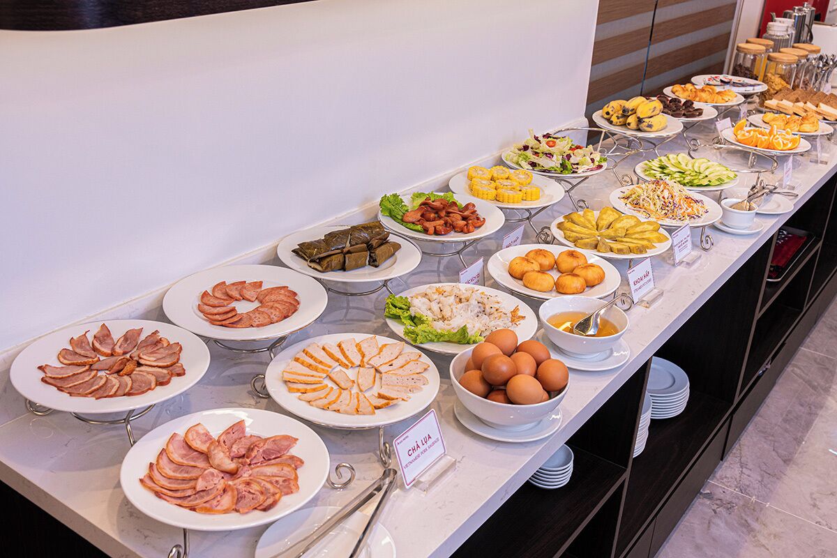 Un buffet con diverse pietanze, tra cui carni, frutta e insalate.