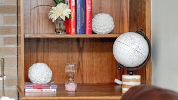 A wooden bookshelf with books, a globe, decorative spheres, and an hourglass.