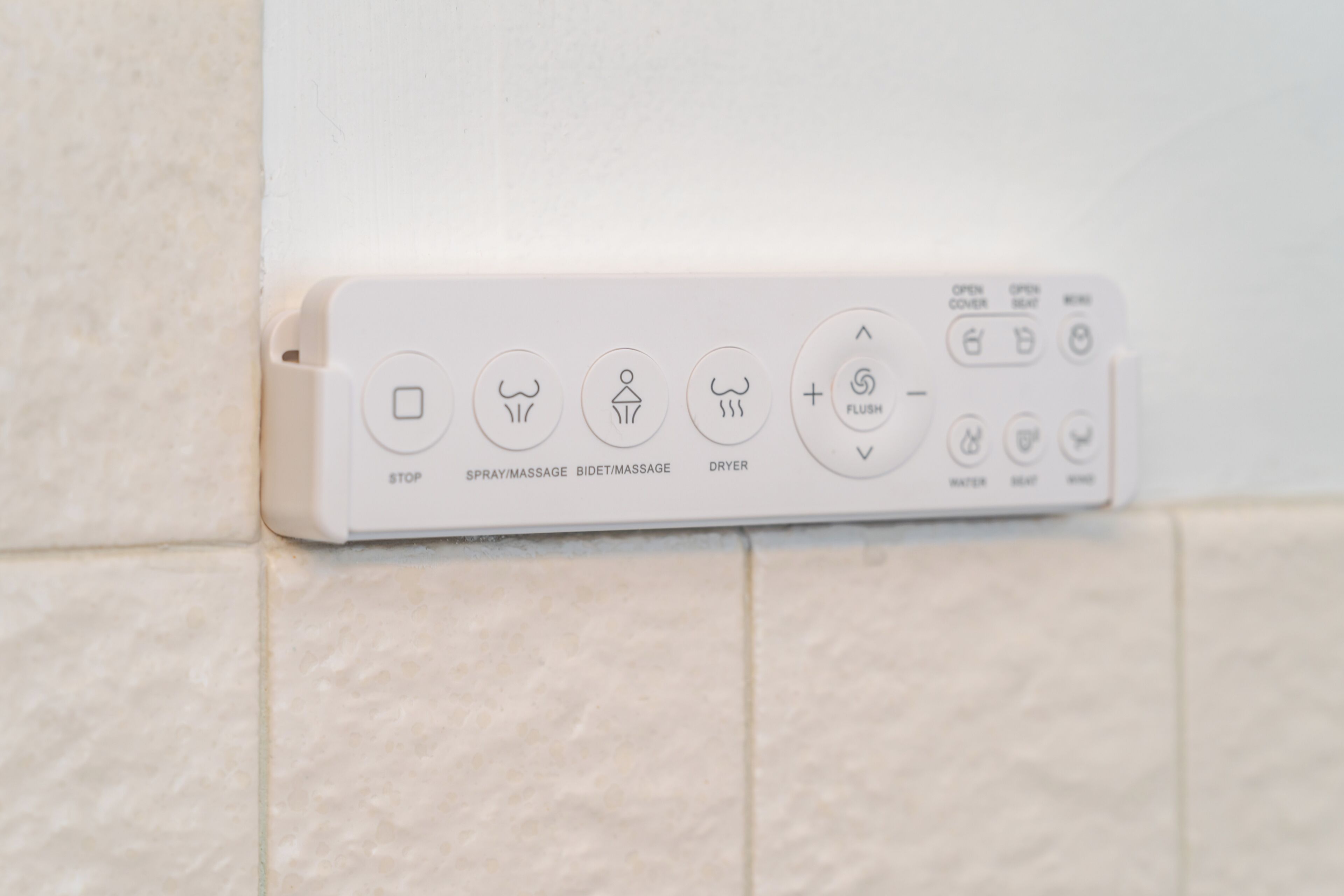 Panel de control con iconos para detener, rociar/masaje, bidé/masaje y funciones de secador.