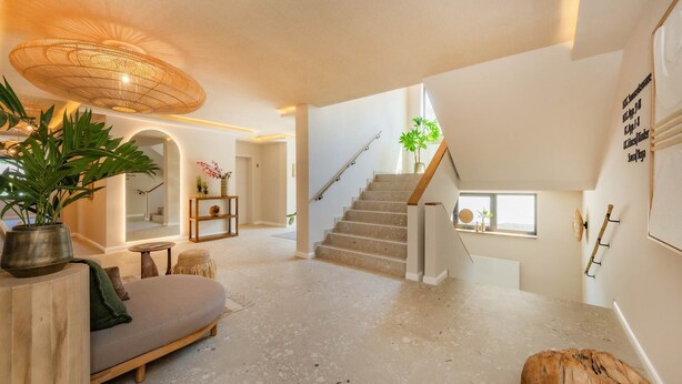 A spacious living area with a staircase, a sofa, and a large plant. - BaliBlizz apartment 03 with whirlpool, sauna and fitness room for 4 people (Benz)