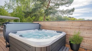 A hot tub on a wooden deck with a potted plant nearby. - BaliBlizz apartment 03 with whirlpool, sauna and fitness room for 4 people (Benz)