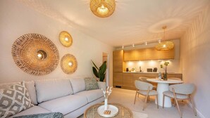 A modern living room with a sofa, a round coffee table, and a dining area with chairs and a table. - BaliBlizz apartment 03 with whirlpool, sauna and fitness room for 4 people (Benz)