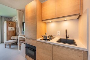 Eine moderne Küche mit Holzschränken, einem eingebauten Herd und einer Spüle.