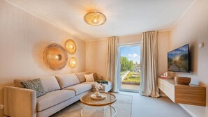 A modern living room with a sofa, a coffee table, a TV, and a large window with curtains. - Bali Blizz apartment 18 with sauna, whirlpool and terrace in Benz (Benz)