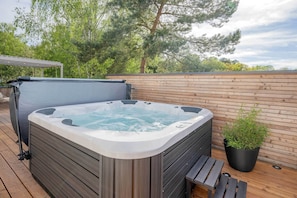 A hot tub on a wooden deck with a potted plant nearby. - Bali Blizz apartment 18 with sauna, whirlpool and terrace in Benz (Benz)