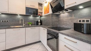 Uma cozinha moderna com forno embutido, micro-ondas e cafeteira.