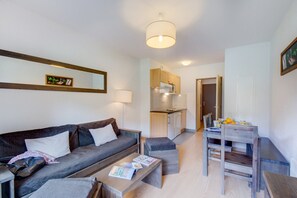 Ein modernes Wohnzimmer mit Sofa, Couchtisch und Essbereich mit Tisch und Stühlen.