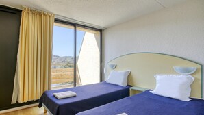 A hotel room with two beds, a large window, and a view of the outdoors. - Accessible Lake Stay for 4 in Miremont (Miremont (PUY DE DÔME))