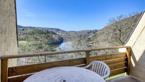 A balcony with a view of a river and hills. - Accessible Lake Stay for 4 in Miremont (Miremont (PUY DE DÔME))