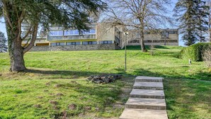 A grassy area with a stone staircase leading up to a building with a modern architectural style. - Accessible Lake Stay for 4 in Miremont (Miremont (PUY DE DÔME))