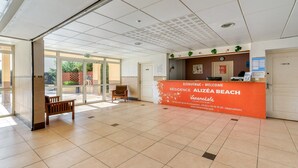 Un'area di accoglienza con reception, una panca e vista sull'esterno.