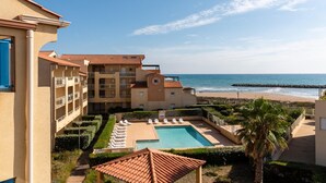 Un resort con piscina, vista sulla spiaggia e diversi edifici.