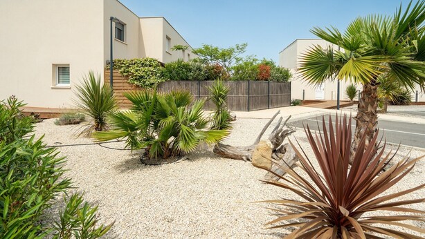 A residential area with modern houses, a gravel driveway, and various desert plants. - Coastal Retreat near Sandy Beach (SERIGNAN (HÉRAULT))