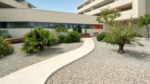 A modern building with a curved pathway, a small tree, and a bench. - Coastal Retreat near Sandy Beach (SERIGNAN (HÉRAULT))